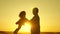 Father and little daughter whirl in dance at sunset. concept of happy childhood. Dad is dancing with child in her arms