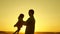 Father and little daughter whirl in dance at sunset. concept of happy childhood. Dad is dancing with child in her arms