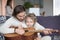 Father and little son with guitar on couch