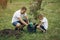 Father with little son are planting a tree on a yard