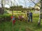 Father and little son work together in a garden with a rake and a wheelbarrow