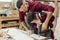 Father and little son working with drill perforating wood plank at workshop