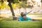 Father lying on grass, with excited happy little child son on shoulder. Carefree two man generations family having fun.