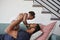 Father Lying On Sofa At Home Lifting Baby Daughter Into Air