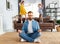 Father meditating in room with playful kids