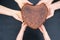 Father, mother and child hands holds rye whole grain yeast-free sourdough bread in shape heart, small family business