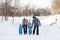 Father, mother and children, twins hold each other hands and walking on the snow