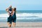 Father, mother, funny baby son walk by beach along sea