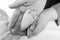 Father or mother holding foot of newborn baby. Adult hand and baby tiny baby feet. Happy parenthood, carefree childhood