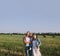 Father and mother hug her little daughter outdoor in field