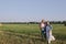 Father and mother hug her little daughter outdoor in field