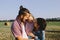 Father and mother hug their little daughter outdoors in field