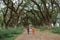 Father and mother raise their daughters hands and carry the child while walking