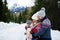 Father and mother with small child in winter nature, standing in the snow.