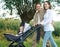 Father and mother smiling outdoors and walking baby in pram