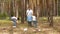 Father, mother and son collect garbage in a bag in the forest or Park. Education of children`s attitude to nature