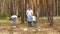 Father, mother and son collect garbage in a bag in the forest or Park. Education of children`s attitude to nature