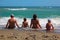 Father, mother, son and daughter sitting on beach