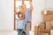 Father, mother and son in new apartment with cardboard boxes. Family is taking selfie on phone.