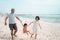 Father and mother swinging a little girl on the beach