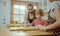 Father and mother teaching baby son kneading dough on kitchen counter at home. Parents and boy kid enjoy and fun indoors activity