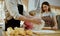 Father and mother teaching baby son kneading dough on kitchen counter at home. Parents and boy kid enjoy and fun indoors activity