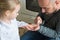 Father painting daughters finger nails