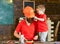 Father, parent with beard in helmet teaching son to use different tools in school workshop. Boy, child cheerful holds