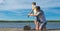 Father on the pier helps his son to keep a fishing rod for fishing, against the blue lake and sky