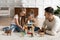 Father play with daughters building tower with wooden blocks