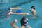 Father playing with daughters in swimming pool
