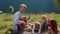 Father playing guitar nature. Happy family singing sitting blanket at picnic.