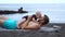 Father playing with his son baby beach on black sand beach on Atlantic ocean background. Hold hands and laugh
