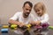 Father plays with child with colorful animals made from playdough