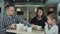 Father pouring tea to his wife and daughter in restaurant. Mother petting daughter on the head.