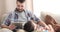Father reading ebook to son relaxing on his lap at home
