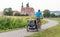 Father riding a bicycle with children in trailer