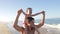 Father Running Along Beach Carrying Daughter On Shoulders