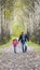 The father runs with a daughter and holds her hand on nature on autumn day vacation. Dad and girl walking and playing in the park