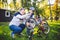 Father`s day Caucasian dad and 5 year old son in the backyard near the house on the green grass on the lawn repairing a bicycle,