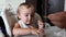 Father`s hand feeds the little girl with soup. Close-up