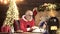 Father in santa costume at home. Portrait of happy Santa Claus sitting at his room at home near Christmas tree reading