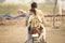 Father and schoolgirl riding motorbike in village