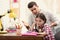 Father scolding his daughter while helping with homework at table