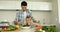 Father showing his son how to toss a salad