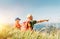 Father showing something interesting to his teenager son sitting on the grass during their mounting hiking walking