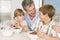 Father Sitting With Children As They Eat Breakfast