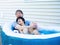 Father sitting in hot tub with disabled son outdoors laughing