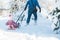 Father sledding his little daughter in the winter in the snow.