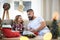 Father with small daughter indoors at home at Christmas, reading book.